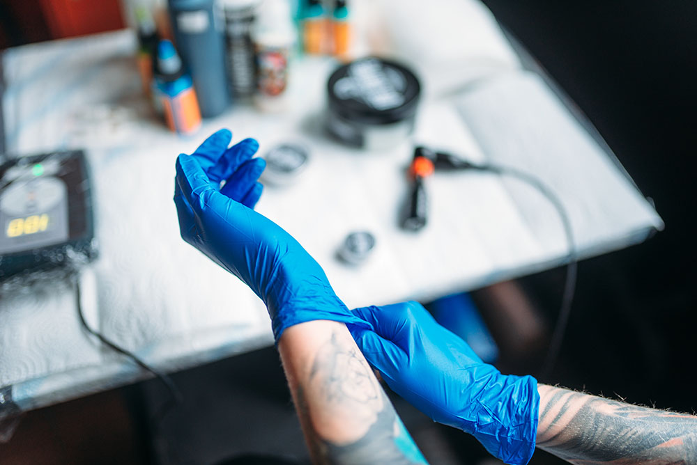 Tattoo artist preparing a sterile workstation in a clean tattoo studio.