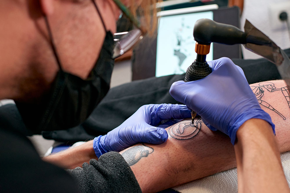 Client receiving a custom tattoo from a professional artist.