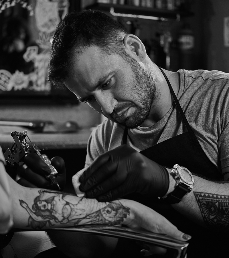 Tattoo master is creating a new tattoo for customer